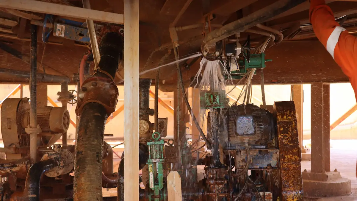 Industrial pump station with a visible water leak, suggesting a need for maintenance.